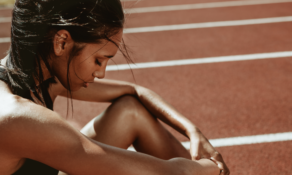 girl hanging here head on running track