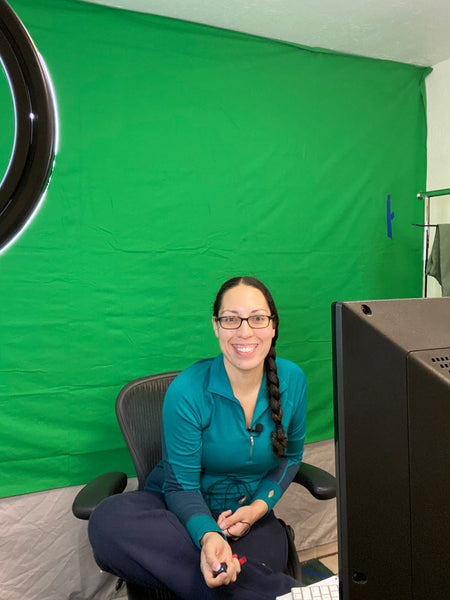 Alpine Parrot Founder and CEO, Raquel, smiling in front of a green screen. 