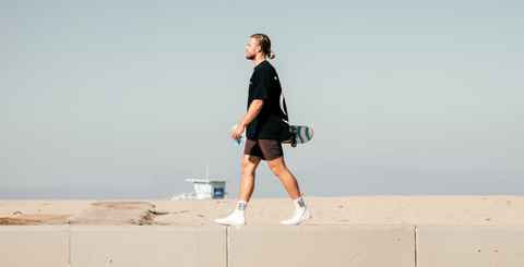 A skater man holding his skate and CBD Capsules