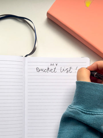 Writing 'Bucket List' in a lined journal