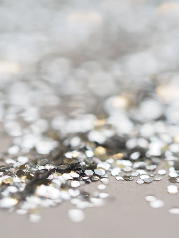 un gros plan de paillettes argentées sur une table. Photo de Jess Bailey sur Unsplash