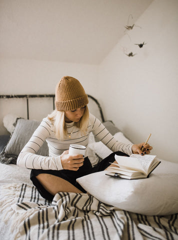 lady reading a book in her bed. Photo by Kinga Howard on Unsplash