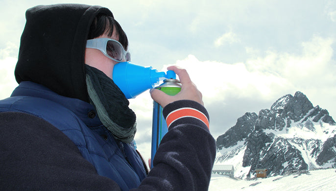 A person breathes canned oxygen in the mountians.