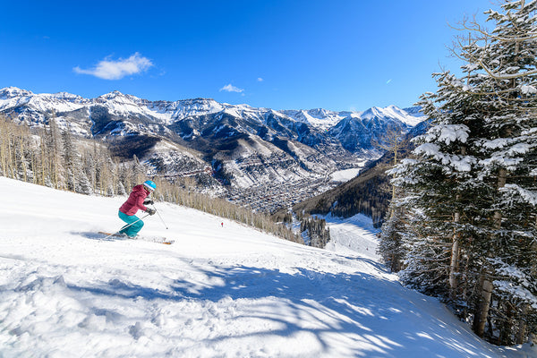 Skier has her hands up.