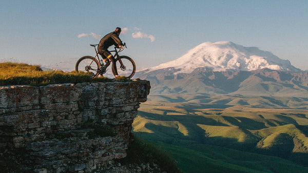 A man overlooks a mountain while sitting on his mountain bike.