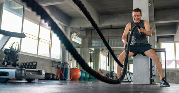 A man uses the dynamic ropes at the gym.