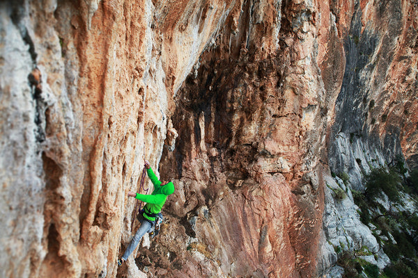 A person climbs a cliff wall.