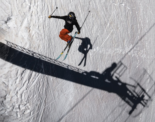 Skier Benni Solomon gets horizontal under a chair lift tower.