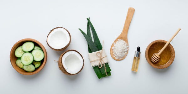 natural skin care ingredients like coconut, aloe vera and honey in a flat lay display.