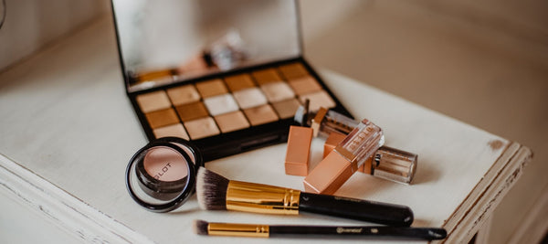 Makeup pallete and makeup tools on a white dressing table