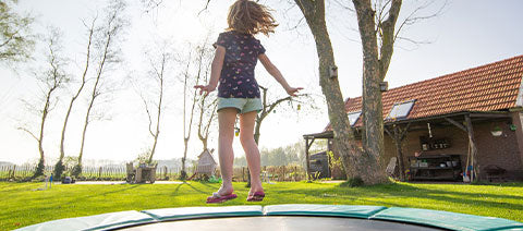 kids jumping on a commercial trampoline in the backyard