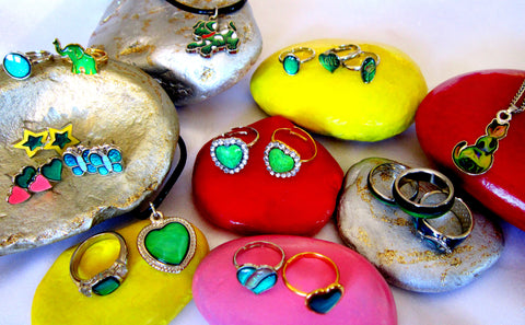 children's mood rings and mood necklace lying on colorful stones