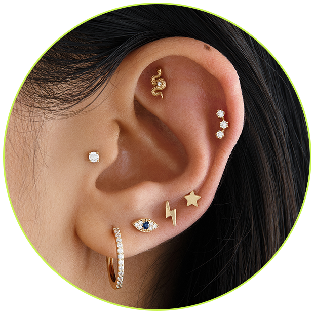 An image of an ear with multiple piercings and earrings.