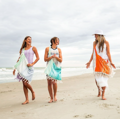 Women walking on a beach wearing Beachables convertible towels