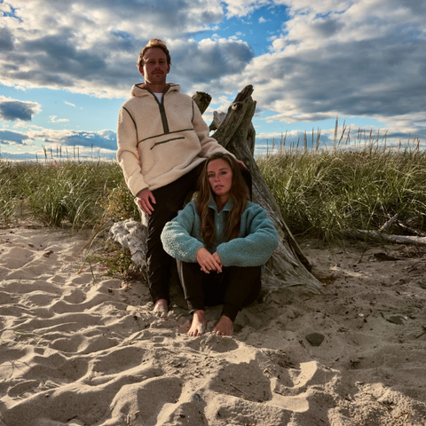 Couple sitting on sand wearing Sherpa Fleece