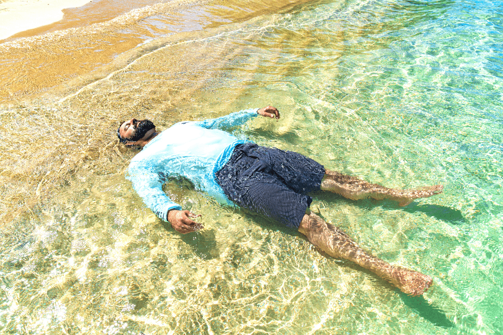 Guy-floating-in-the-ocean-in-sun-protection-clothing