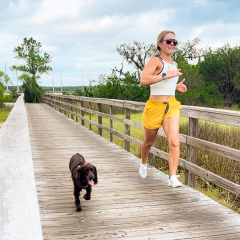 Woman wearing Vapor Apparel running with a dog