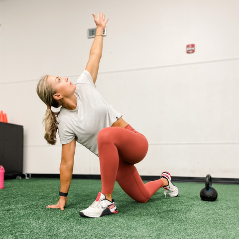 woman wearing Vapor Apparel stretching at the gym