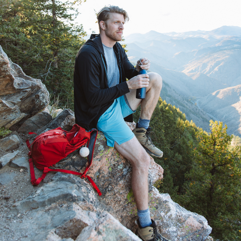 Man wearing fall layers sitting on a mountain