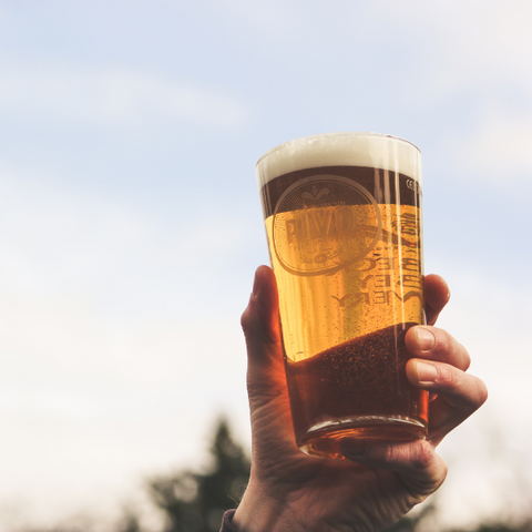 Person holding a glass of beer