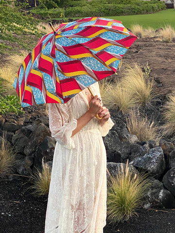 woman holding a portable lightweight sun umbrella parasol to protect her skin from the damaging UV rays that cause sunburn and premature aging