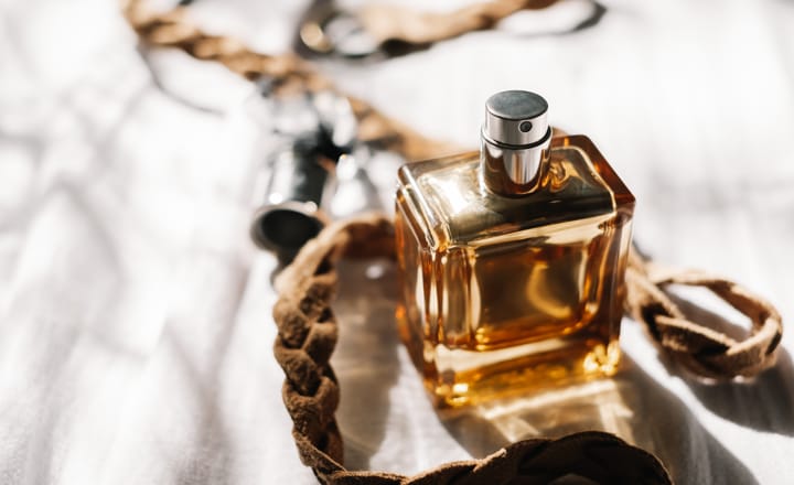 a leather hair braid next to a bottle of cologne