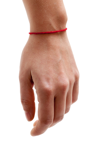 Red string bracelet on left hand