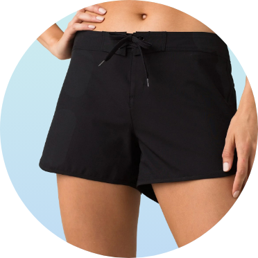 Woman wearing black swim shorts with a drawstring waist. The swim shorts are designed for comfort and mobility, ideal for swimming and water activities.