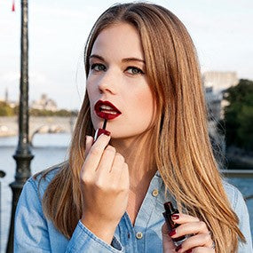 Blogueuse Gaelle VP s’applique du rouge à lèvres bordeaux et porte du vernis à ongles bordeaux