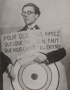 André Breton en 1920, lors d'un festival Dada à Paris, portant une pancarte conçue par Francis Picabia