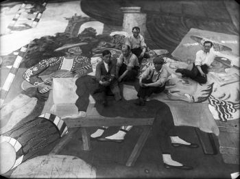 Pablo Picasso et des peintres de scène assis sur la toile de fond pour le ballet Parade au Théâtre du Châtelet, Paris, 1917
