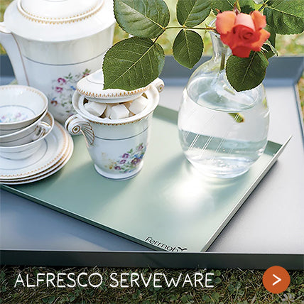 Delicate porcelain and a vase rest on a serving tray