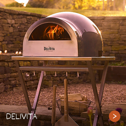 A pizza oven cooks pizza on a warm evening