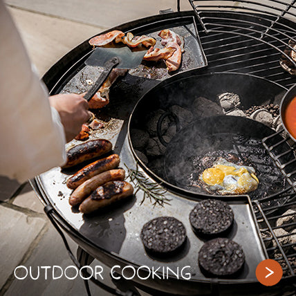 A man cooks a delicious full English breakfast on an outdoor grill