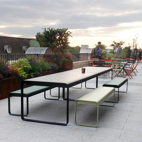 An outdoor office with long benches and tables