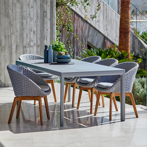 A set of grey tables and chairs on a marble patio