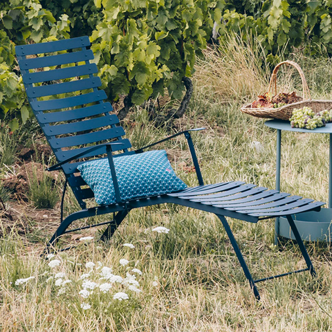 A blue sun lounger on a grassy plain