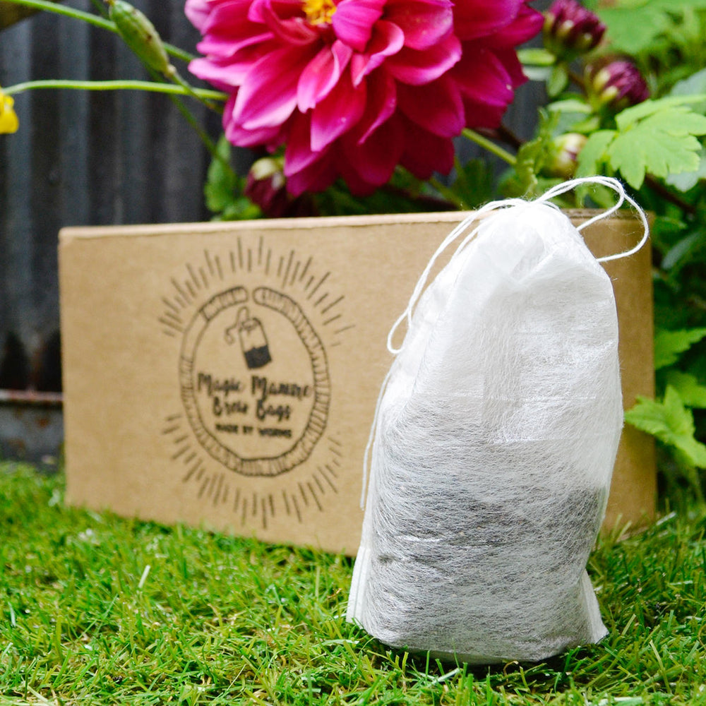 A bag of manure in front of a healthy flower