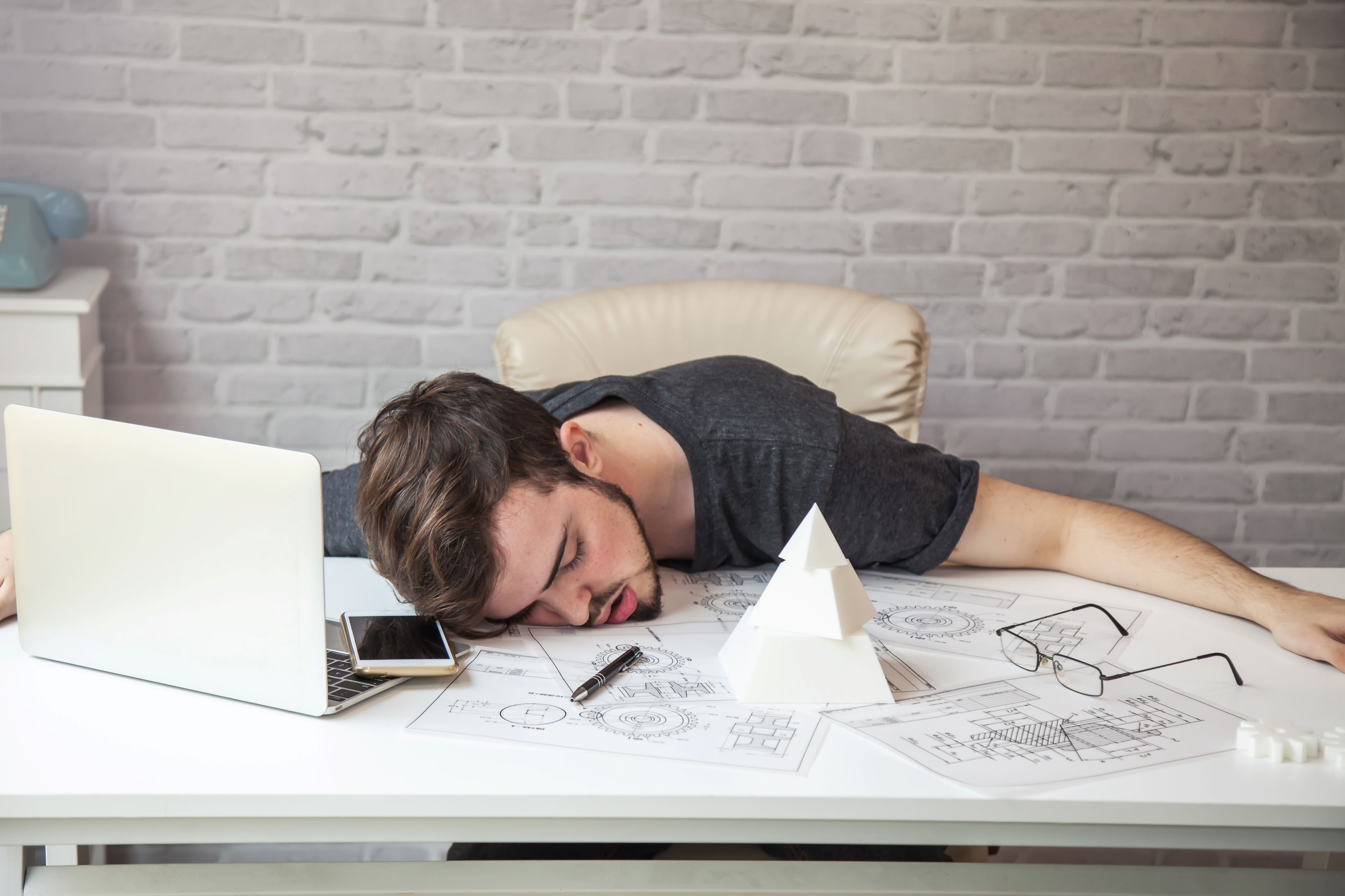 tired man collapsed on his desk at work