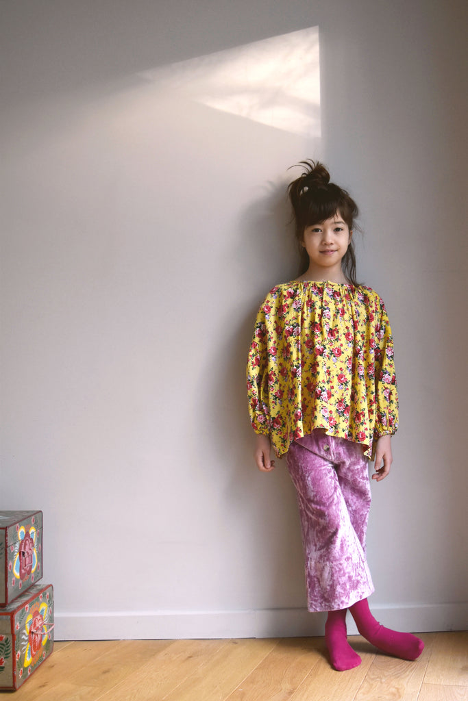 lulaland Fall No.15 Mirage collection. Girl wearing a flower yellow blouse and velvet purple pants. Organic girl's clothes