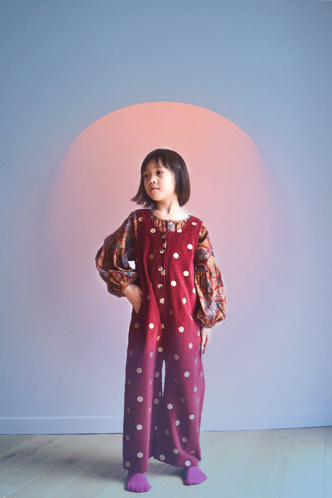 lulaland Fall No.15 Mirage collection. Girl wearing an oversized blouse with leafy print and polka dots red romper. Organic girl's clothes