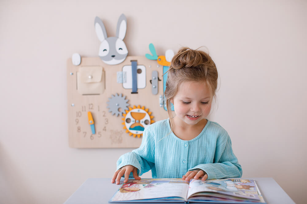 Une petite fille lit des livres pour enfants