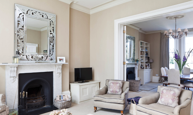 Venetian decorative mirror hangs over a fireplace mantel in living room