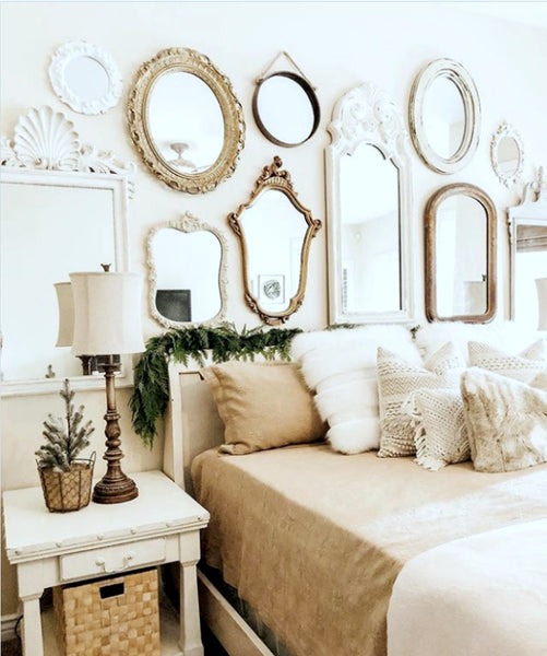 Gallery wall of small modern vintage wall mirrors above bed