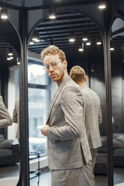 Man trying on suit in front of a mirror
