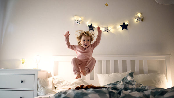 Toddler jumping in bed