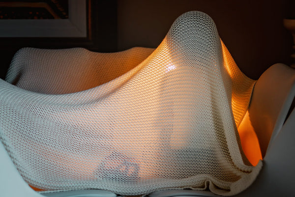 Child under the blanket with lamp