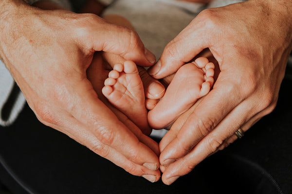 dad hands and baby feet
