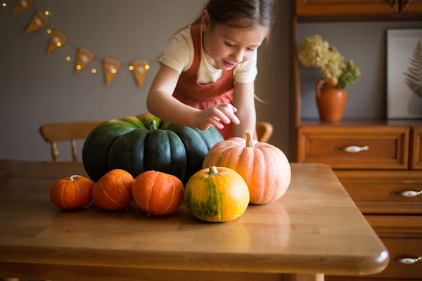 Girl on the table with pumpkins