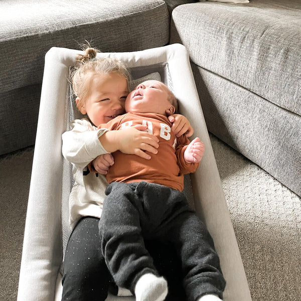 Sister embracing little brother in Bamboo 3DKnit Bouncer
